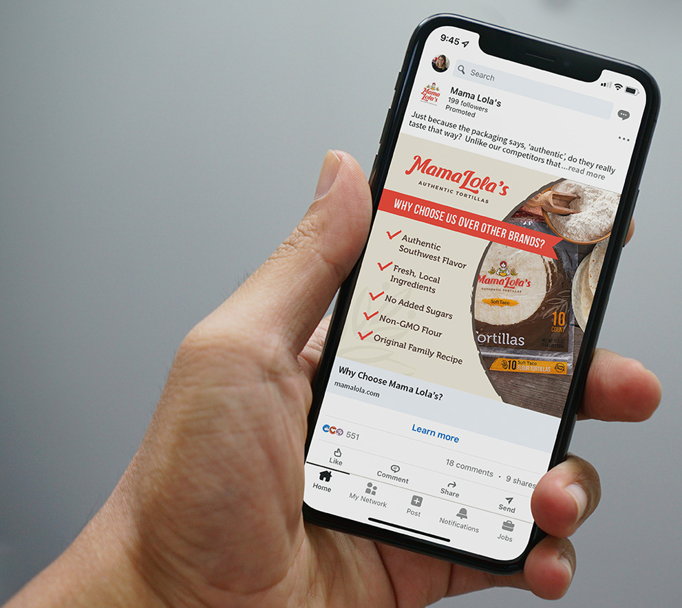 Hand holding a smartphone with a Mama Lola's tortillas ad on social media, showcasing delicious product benefits